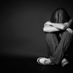 woman in depression and despair crying on black dark